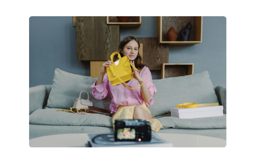 A content creator filming Amazon product videos, showcasing a yellow handbag for AI-powered eCommerce marketing.